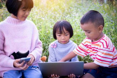 Çocuklar büyüteçle ormanda keşfe çıkıyorlar.