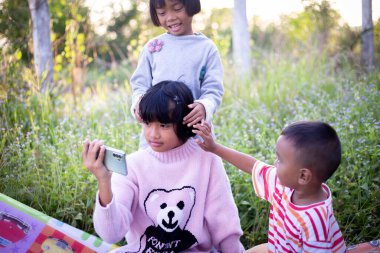 Çocuklar büyüteçle ormanda keşfe çıkıyorlar.