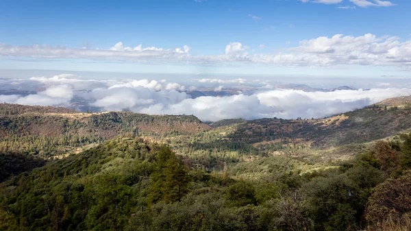 stock image Beautiful vistas of the valleys and forests of Kings Canyon and Sequoia National Park, with low clouds and blue skies