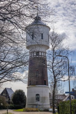 Hollanda 'nın Drenthe ilinin Van Heutszpark adlı parktaki kale hendeğine yerleştirilmiş Coevorden kasabasındaki eski su kulesi.