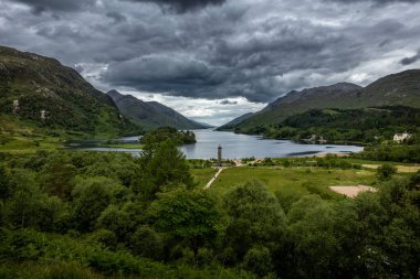 İskoçya 'da bir yaz günü Glenfinnan' da gökyüzü bulutlu ve Loch Shiel ve Glenfinnan anıtı manzaralı manzara fotoğrafı..