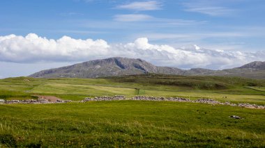 Beautiful dry stone walls, meadows, mountains and beautiful cloudy skies in the far northwest of Scotland close to Cape Wrath clipart