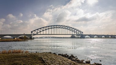 View of the old IJssel bridge also called Katerveer bridge, on a sunny winter day. The bridge crosses the river IJssel from the Hanseatic cities of Zwolle to Hattem, province of Overijssel. clipart