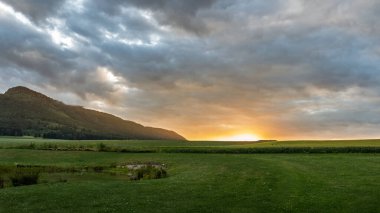 Polonya sınırındaki Kuzey Bohemya 'nın Bozanov köyü yakınlarındaki güzel Çek bölgesinde Koruna Dağı manzaralı gün batımı