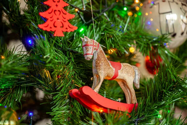 摇曳的马挂在圣诞树上 上面有球和灯 — 图库照片