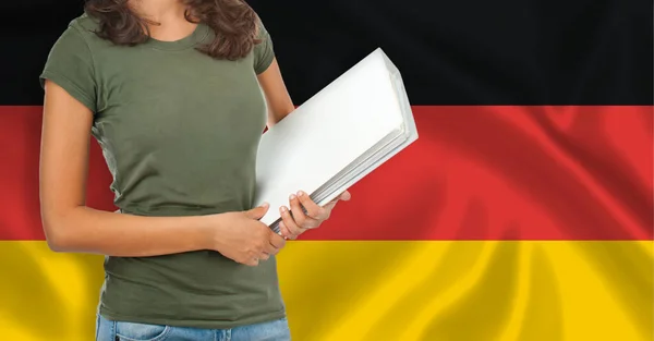 フォルダを持つ女性学生の半長の肖像画 外国語教育の概念ドイツ語の旗 — ストック写真