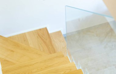 Meşe parke kaplı merdiven sertleştirilmiş cam balyoz ve krom raptiyelerle kaplı..