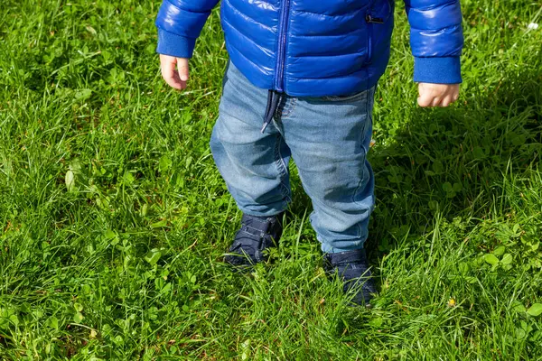 Close Young Child Blue Taking Tentative Steps Outdoors Vibrant Green Stock Picture