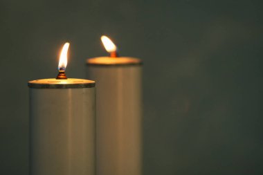 İki mum yanıyor, ruhsal bir atmosfer yaratıyor sessiz bir düşünce ve dua için mükemmel.