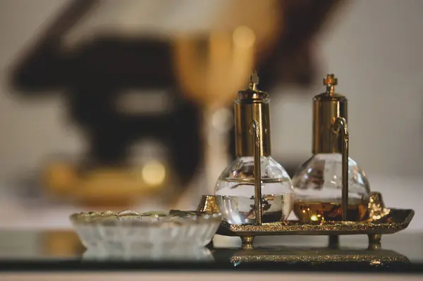 Stock image Two glass and brass containers holding holy water and chrism oil, essential for catholic baptism and confirmation ceremonies