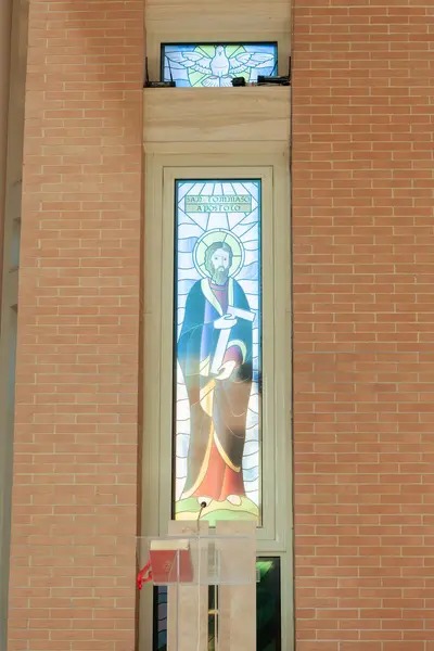 stock image Stained glass window depicting saint jude thaddeus holding a crucifix in a modern church