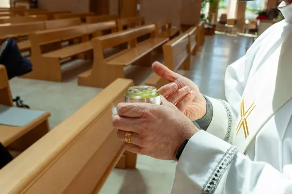 Stock image Priest wearing a stole and holding a silver jar containing the holy chrism oil, used for the sacraments