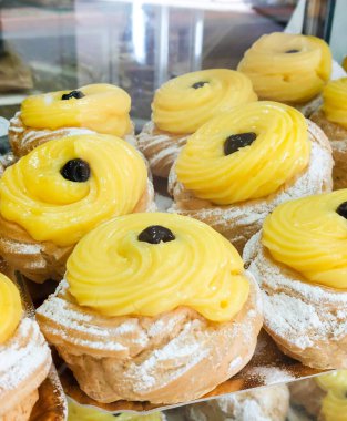 Ağız sulandıran zeplinlere yakından bakın. Klasik İtalyan hamur işleri muhallebi dolu ve üstü koyu kirazla süslenmiş.