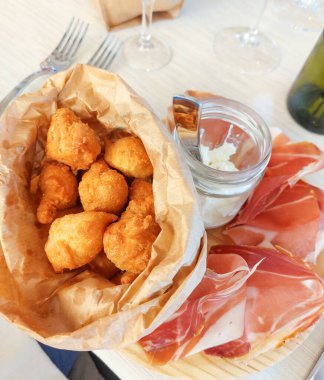 Yakından bakınca kızarmış hamur topları, prosciutto ve stracchino peynirinden oluşan nefis İtalyan aperatif tabağını yakalayın.