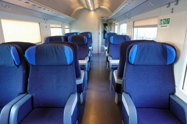 Boş mavi koltuklar bir tren vagonunda, yolcuların binmesi için hazırlanıyor.