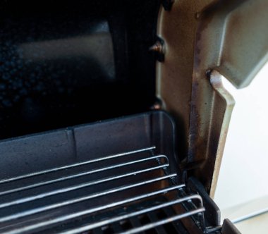 Izgara kapağı menteşesi kirli, kararmış ve yağla kaplanmış. Temizlemesi zor alan.