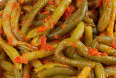 Lezzetli bir domates sosuyla kaplanmış haşlanmış yeşil fasulye sağlıklı ve lezzetli bir yemek yapıyor.