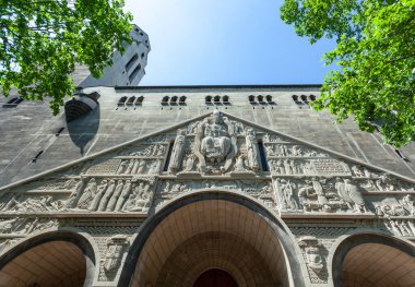 Aziz Pierre de Montrouge Kilisesi 'nin etkileyici cephesinin düşük açılı görüntüsü oymalar, heykeller ve dini sahneler gösteriyor.