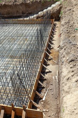 Çelik güçlendirme çubukları ve ahşap işçiliği beton bir temel oluşturarak inşaatta istikrar ve dayanıklılık sağlar.