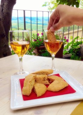 Cantucci ya da cantuccini adı verilen tipik Toskana bisküvileri, Péenza, Toskana, İtalya 'da manzarası olan vin Santo tatlı şarabına batırılır.