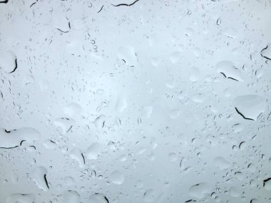 Yağmurlu bir günde cam camında kayan su damlaları büyüleyici bir soyut desen oluşturur.