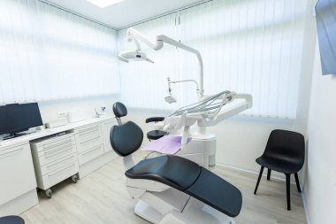 Modern aletlerle dolu boş bir dişçi ofisi. Dişçi koltuğu, lamba ve aletler dahil. Hastalar için hazır.