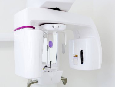 Parlak, steril klinik ortamında dişçi panoramik röntgen cihazının kesilmesi, kesin tanı ve hasta bakımının sağlanması.