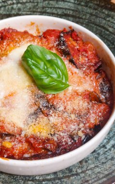 Patlıcan, patlıcan, patlıcan, domates sosu, mozzarella ve üzerine taze fesleğen katılmış parmesan peyniri.