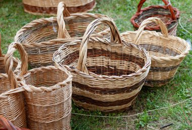Geleneksel tekniklerle el yapımı farklı şekil ve boyutlarda hasır sepetler bir çimen yüzeyinde uzanıyor.