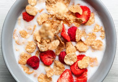 Mısır gevrekleri ve dondurulmuş meyveler bir kase süte dönüşüyor canlı ve besleyici bir kahvaltı yaratıyor ve sağlıklı beslenme alışkanlıklarını teşvik ederek güne lezzetli bir başlangıç sağlıyor.