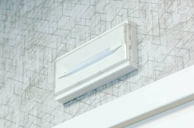 Beyaz acil durum ışığı desenli bir duvara monte edildi, bölgeyi aydınlattı ve elektrik kesintileri sırasında güvenlik önlemi olarak hizmet verdi, kritik durumlarda görünürlük ve rehberlik sağladı