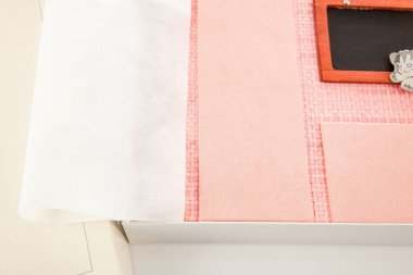 Beyaz bir kutunun içine yerleştirilmiş koruyucu bir sayfanın yer aldığı pembe bir fotoğraf albümünün yakın görüntüsü, değerli anıları ve yaratıcı projeleri korumaya hazır olduğunu vurguluyor