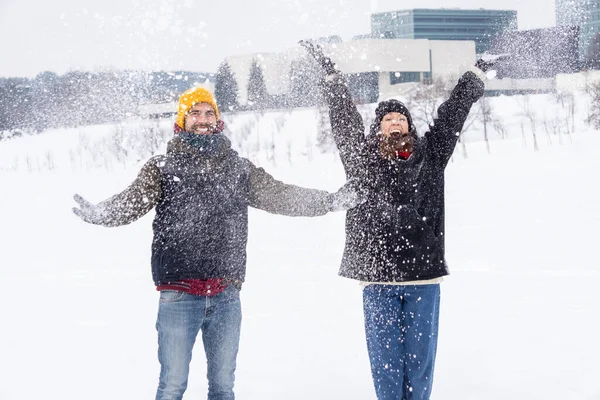 Couple throwing snow and enjoying winter. Couple throwing snow and enjoying winter time in field, full of snow