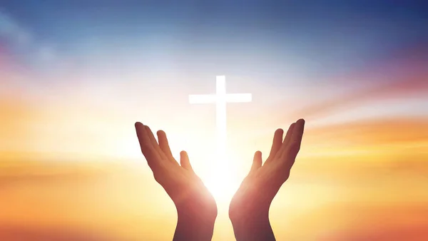 人間の手は白い上に十字架と日没の背景に崇拝神を開きます — ストック写真