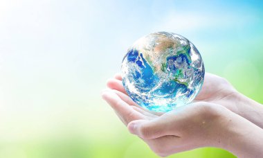 Dünya Çevre ve Toprak Günü, Dünya 'yı bulanık yeşil ve mavi gökyüzü arka planının üzerinde tutan insan elleri. Bu görüntünün elementleri NASA tarafından desteklenmektedir