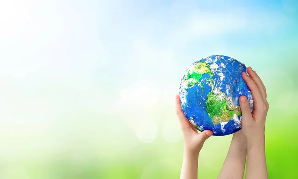 stock image  world environment and earth day, Human hands holding earth globe over blurred green and blue sky nature background. Elements of this image furnished by NASA