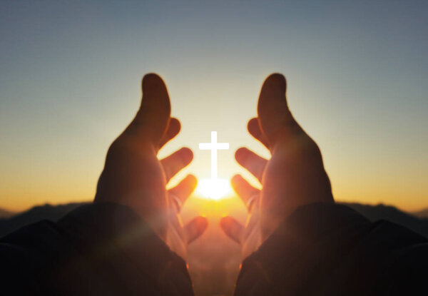 молитвенная концепция, руки человека открывают ладонью вверх поклонение с восходом солнца на фоне креста