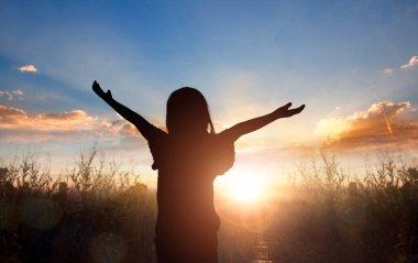 Güzel alacakaranlık günbatımında mutlu genç bir kadının silueti.