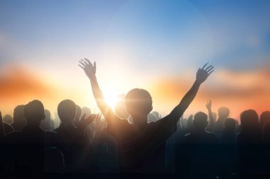 Çapraz manevi ışık arka plan üzerinde bulanık üzerinde yükselen siluet Hıristiyan insanlar el