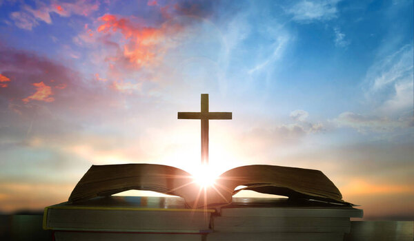 Открытая книга с крестом на фоне заката. Христианская. 3D рендеринг