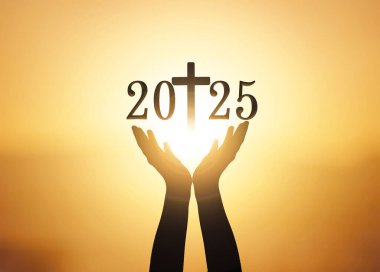 Silhouette of hands holding the new year 2025 and cross over sunset background clipart