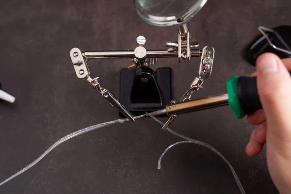 man soldering two small wires. High quality photo