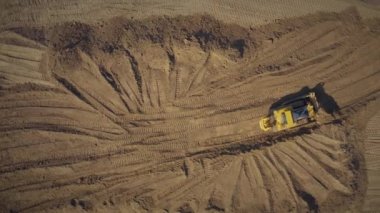 Sarı, Buldozer 'in bir kova ile yere düştüğünü tespit etti. Dünya inşaatı işe yarıyor. Bir buldozerle yol yapımı.