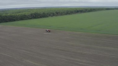 NPK gübre uygulamaları bir araştırma alanı. Gübreleme için traktör havadan panorama drone atışı yapıyor. Tarım makineleri baharda tarlada. 