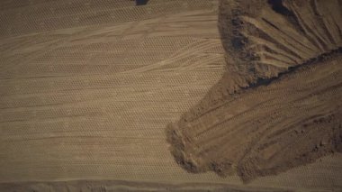 Yol inşaatı için kum tabanını sıkıştıran paten. Üst görüş hava aracı görüntüsü. Dünya inşaatı işe yarıyor. Yol silindirli bir yol yapımı.