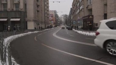 Luxurious white Infiniti car drives through the streets of downtown Kyiv on a cloudy day. Close-up view with car details. Perfect video for car advertising, tourism, and travel.