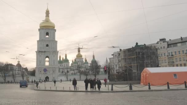 人々は通りを渡って聖ソフィア教会の鐘楼を背景に横断歩道に移動します 戦争中のキエフ中心部の路上での生活 2023 キエフ ウクライナ — ストック動画