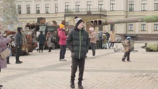 2023年春 ロシアによるウクライナ侵攻の際の燃え尽きた軍事装備の中 キエフのミハイルヴァスカ広場を歩く人々 2023年3月1日 キエフ ウクライナ — ストック動画
