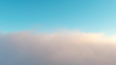 Güneş, mavi gökyüzündeki kümülüs bulutlarını delip geçerek manzarada nefes kesici bir meteorolojik fenomen yaratıyor.