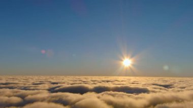 Güneş gökyüzündeki bulutların arasından gözetleyerek doğal ortamda sakin bir atmosfer yaratıyor. Ufuk, sıcaklık ve sükunetle aydınlanır.
